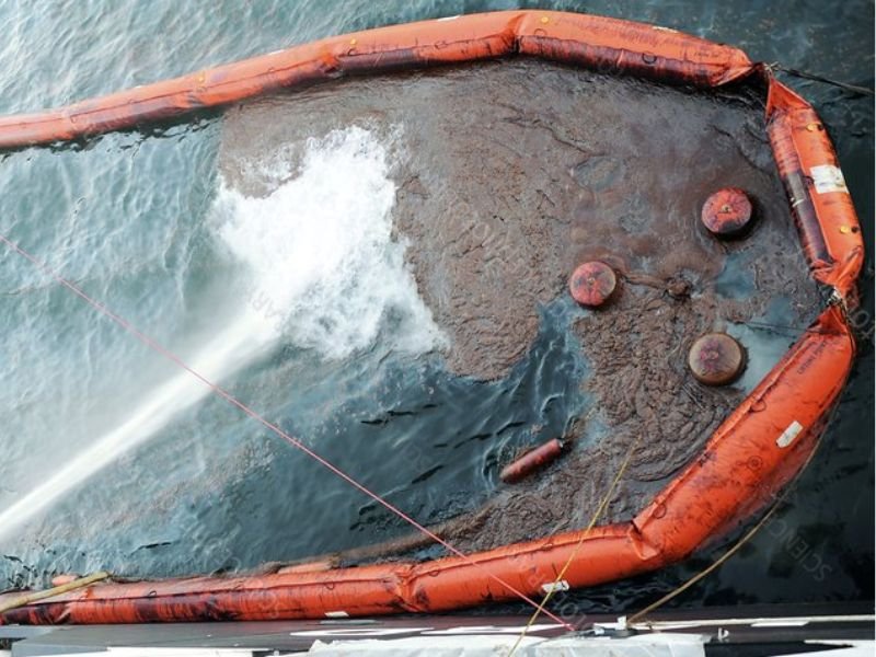 Durable industrial oil booms protecting water body from oil spill containment